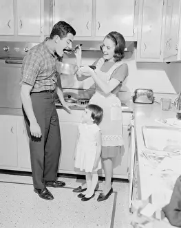 Family with daughter (2-3) preparing food in kitchen