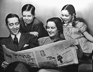 Family reading newspaper