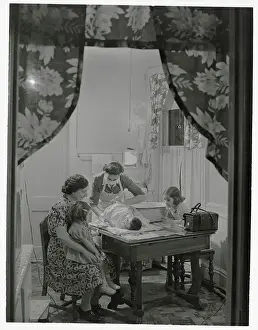 Family Watching Visiting Nurse Changing Diaper on Baby