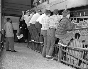 Fans Watching Game Through Fence
