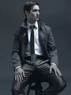 Relax Collection: Fashion shot of a man in a suit and jacket, sitting on a stool