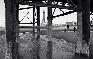 Blackpool Gallery: Father with children (10-13) on beach, view through pier supports