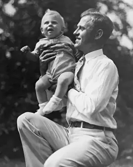 Father holding toddler boy (15-18 months) outdoors (B&W)