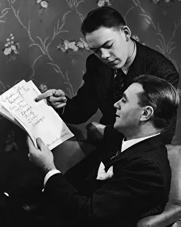 Father and teenage son (16-18) going over school budget (B&W)