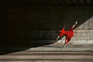 Prints of Female ballet dancer dancing with pointes in the street with a long red dress, in the street of Lyon, France The Enchanting Evolution of Ballet: Female ballet dancer dancing with pointes in the street with a long red dress