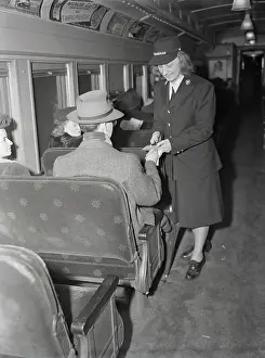 Female Conductor Taking Train Ticket from Passenger