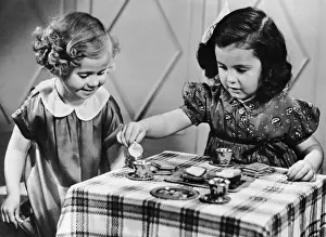 Female siblings having a tea party