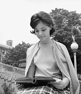 University Student Prints: Female student sitting outdoors, reading book