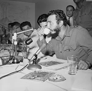 Fidel Castro Drinking From a Cup at Conference Gathering