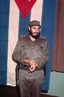 Fidel Castro Standing in Front of Flag With Cigar