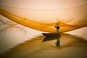 Lijiang Gallery: fisher man check his nets in early morning on river