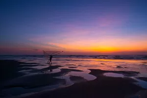 Images Dated 1st June 2014: Fisherman walking on the beach at dawn in Vietnam