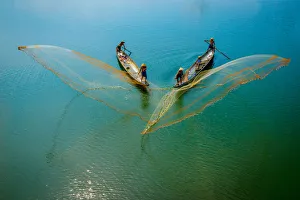 Fishermen throw fishing net on boats to catch fish in Hue