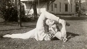 Flexible Woman in a Garden Bending Her Leg Above Her Head