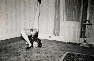 Showing Off Prints: Flexible Woman on the Living Room Floor With Her Leg Over Her Head