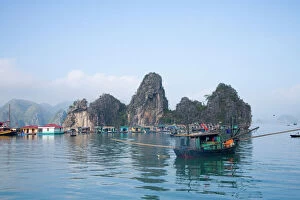 Village Collection: Floating Vietnamese fishing village with rocky coastline