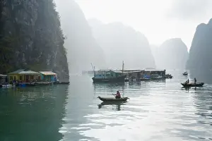 Floating Vietnamese fishing village with rocky coastline