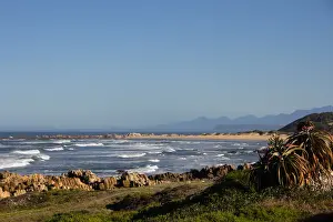 Foamy waves roll over rugged rocks and onto the sandy beach at Buffalo Bay (aka Buffelsbaai)