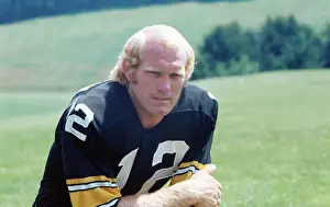 Football Player Kneeling on Grassy Field