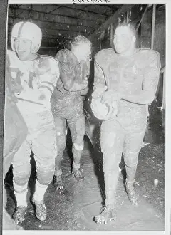 Football Players Covered in Mud