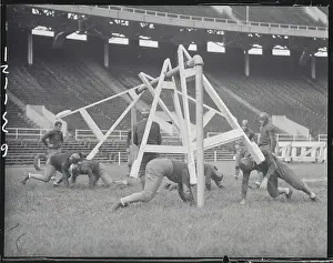 Football Players Practicing with New Tackling Machine