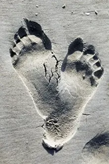High Prints: Two footprints in the sand on a beach