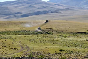 Images Dated 17th August 2015: Four-wheel drive vehicles following dirt road, Khovd Province, Mongolia
