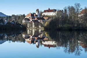 The former Franciscan Monastery of St. Mang, reflection of the castle at top in the Lech river, Fuessen
