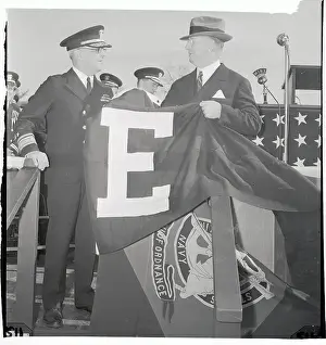 Frank Knox Holding a Pennant with the Letter E