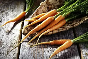 Images Dated 25th May 2012: Fresh carrots, carrots in a wicker basket on rustic wood