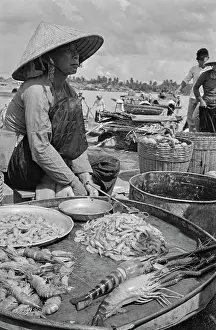 Prints of A Vietnamese woman, wearing a traditional non la hat, selling seafood on the embankment of the Saigon River as it flows through Saigon, Vietnam, 30th August 1965 Vietnam Prints: Freshly Caught Seafood, Saigon River