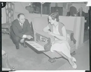 Furniture Designer Louis Davis Demonstrating Chair to Woman