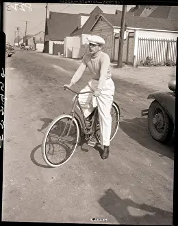 George Raft Seated on Ladies Bicycle