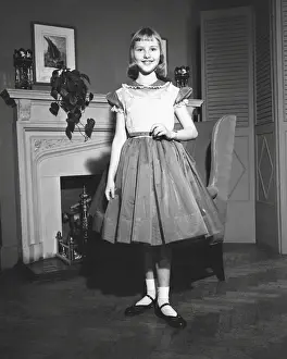 Fireplace Prints: Girl (12-13) posing by fireplace, (B&W), portrait