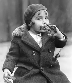 Girl (3-5) face and fingers covered in chocolate
