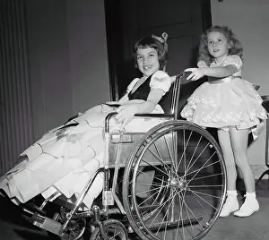 Disabled Prints: Girl (4-5 years) pushing friend on wheelchair