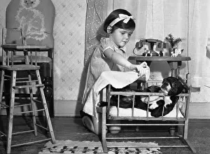 Blanket Prints: Girl (6-7) playing home with dog serving as baby substitute