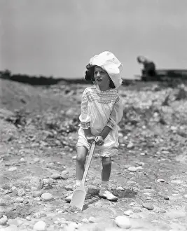 Confusion Prints: Girl (6-7 years) with shovel on beachNarragansett, Rhode Island, USA. July 22, 1914