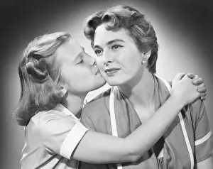 Girl (8-9) kissing mother, (B&W)