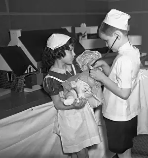 Dressing Up Prints: Girl and boy (8-9) pretending to be nurse and doctor