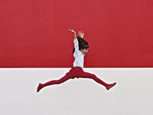 Images Dated 1st January 2012: Girl jumping in air at red wall