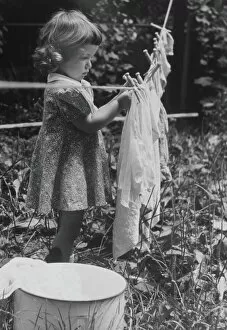 Images Dated 31st August 2005: GIRL PINS LAUNDRY TO CLOTHESLINE, 1944