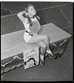 Girl Posing Cheesecake-Like; Pigtails
