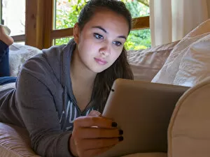 Mobility Collection: Girl reading on a tablet computer at home, Germany