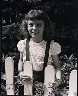 Girl Smiling Behind Fence