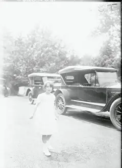 Girl Strolling Past Automobiles