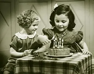 Enjoyment Prints: Two girls (3-4), (4-5) sitting at small table with birthday cake, (B&W)