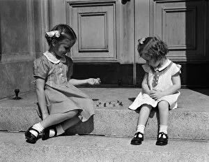 Entrance Collection: Girls sitting on steps outdoors, playing jacks