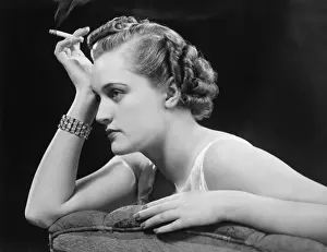 Bracelet Prints: Glamourus woman sitting on sofa, holding cigarette (B&W)