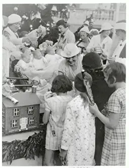 Prints of (Original Caption). Acting as Santa's assistant, Mrs. Henry L. Doherty brought Yuletide cheer to more than 800 children at the Annual Grace Doherty Christmas Party given at the Miami Biltmore Hotel A Timeless Christmas: Vintage Treasures: Grace Doherty Handing Out Christmas Presents